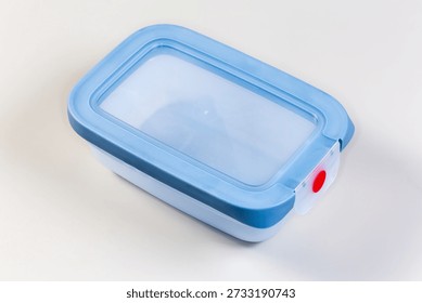 Closed empty reusable blue plastic leakproof translucent lunch box with silicone seals and strong fastener on a grey background
