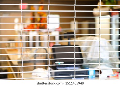 Closed entrance to retail shop. Store closure under COVID-19 omicron variants. Closed wire mesh door front. Small business store closed due to Coronavirus, off business hours concept. Selective focus.