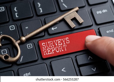 Closed up finger on keyboard with word SURVEYS REPORT