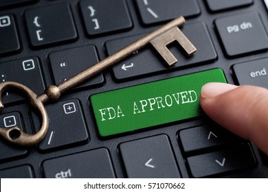 Closed up finger on keyboard with word FDA APPROVED