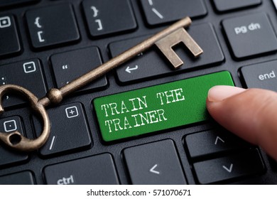 Closed Up Finger On Keyboard With Word TRAIN THE TRAINER