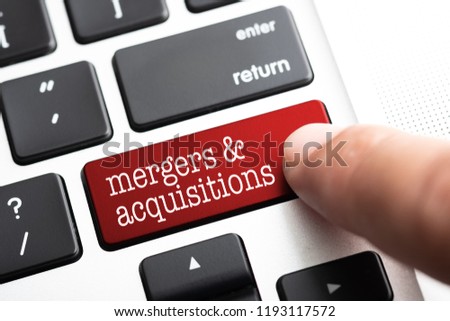 Closed up finger on keyboard with word MERGERS & ACQUISITIONS