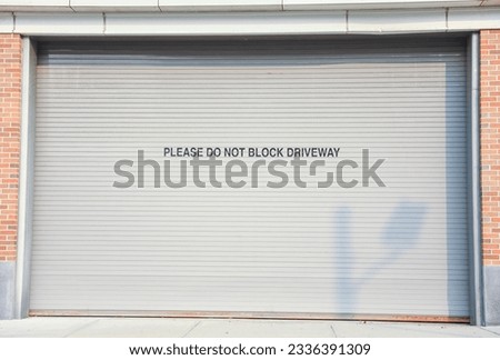 closed garage door symbolizes security, privacy, and hidden potential. The mundane facade conceals untold stories and aspirations