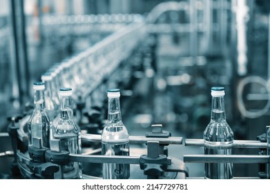 Closed glass bottles of upscale vodka transported by line - Shutterstock ID 2147729781