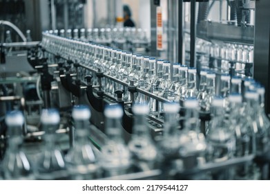 Closed glass bottles of upscale vodka transported by line - Shutterstock ID 2179544127