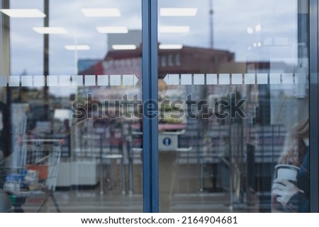 Closed glass supermarket automatic door, front view.
