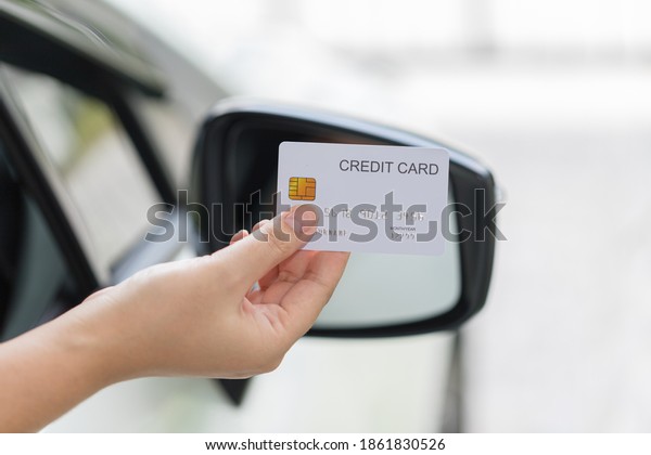 closed up hand use credit card on car to pay or to\
access the gate