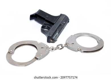 Closed Handcuffs And A Gas Pistol, On A White Background