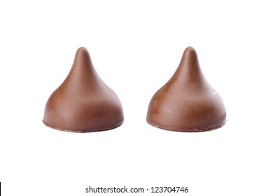 Closed up image of two chocolate kisses against white chocolate