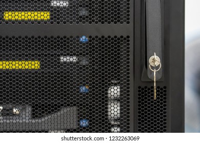 Closed up key inserted in lock handle of rack server. System and network security for business concept. Front view shot.