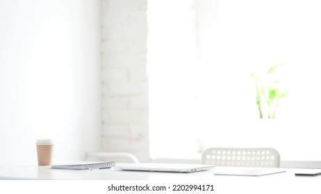 Closed Laptop On Desk In White Loft Office