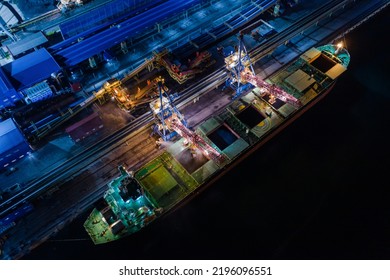 Closed loading of coal on a large cargo ship at a modern coal terminal at night. View from a drone