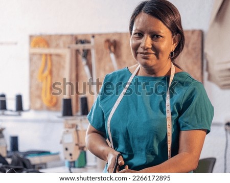 Closed of mature woman portrait in her sewing workshop.