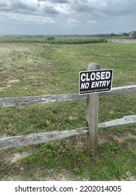 Closed, No Entry Reads The Large Font On A Metal Sign Posted Along A Wooden Pasture Fence At The Edge Of The Private Plot Of Commercial Agriculture Land Boundaries