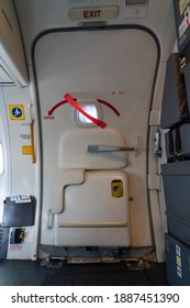 A Closed Passenger Airplane Entrance Door - Inside View - With The Inflatable Emergency Evacuation Slide In Armed Position - Door 1L