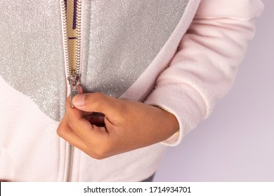 Closed shot of a hand pulling up the closure of a sweater