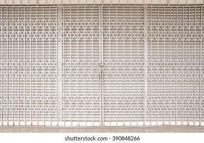 Closed Shutters And Metal Accordion Gate Of A Shop Lot Including Surroundings