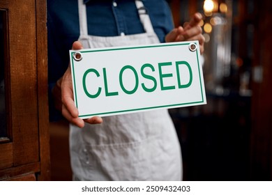 Closed sign, coffee shop and hands of person at entrance of small business for bankruptcy or recession. Closing, economy and financial crisis with employee at door cafe or restaurant for service - Powered by Shutterstock