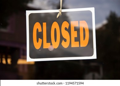 Closed Sign Hanging In Business Window By A String - Crooked With Glob Of Glue Also Attaching It To Window - Some Abstract Reflections