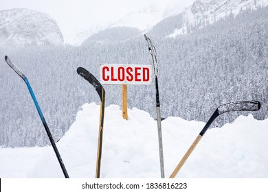 Closed Sign With Hockey Sticks In The Snow.Sport Or Venue Closed Due To Bad Weather Or Coronavirus.