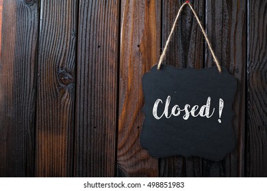 Closed Sign Written In Chalk On Chalkboard On Rustic Vintage Wood Background. Top View Selective Focus.