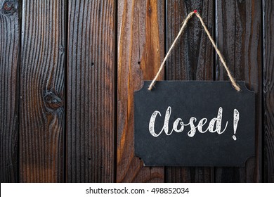 Closed Sign Written In Chalk On Chalkboard On Rustic Vintage Wood Background. Top View Selective Focus.