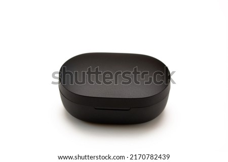 closed small plastic black box on a white background, a case for wireless headphones