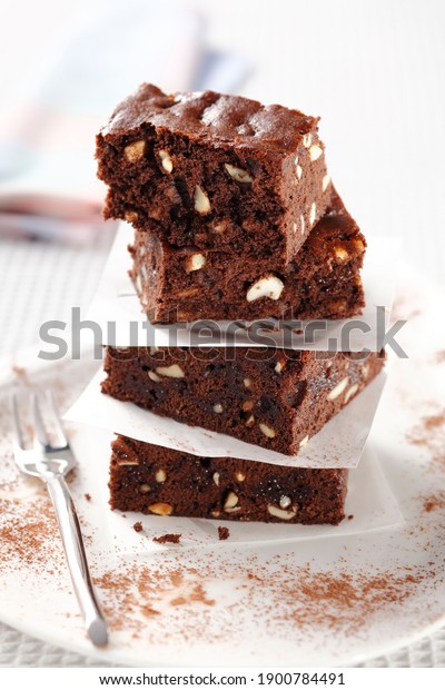 closed up stacked brownies separated by\
baking parchment on white background\
.