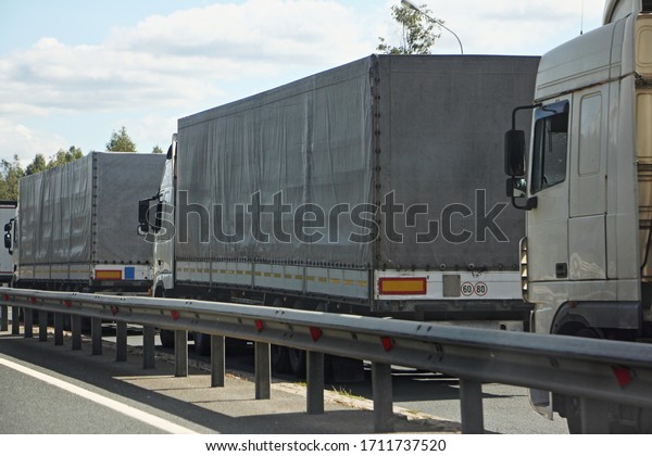 Closed state border, semi trucks\
queue traffic jam on antiviral quarantine control point at spring\
day, international logistics trouble illustration\
concept