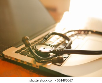 Closed Up Stethoscope On Laptop With Warm Light On Doctor Table