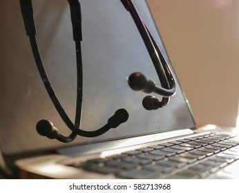 Closed Up Stethoscope On Laptop With Warm Light On Doctor Table