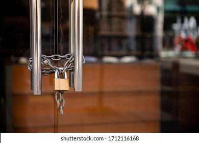 Closed Store due to Coronavirus pandemic. Locked Store Door with Padlock and Chains  - Shutterstock ID 1712116168