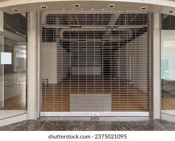 Closed storefront with security gate in an almost vacant 20th-century indoor shopping mall in Florida, for retail, architectural, and vintage motifs of Americana