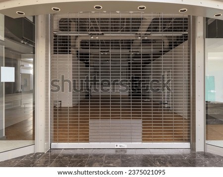 Closed storefront with security gate in an almost vacant 20th-century indoor shopping mall in Florida, for retail, architectural, and vintage motifs of Americana