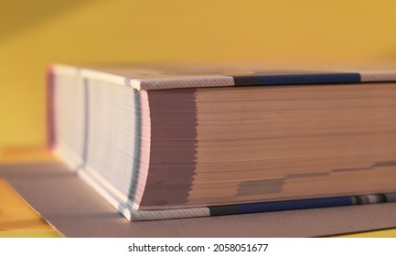 Closed Thick Paper Book Closeup On Yellow Background.