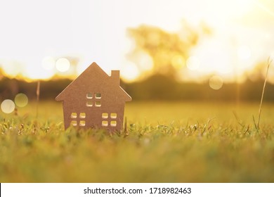 Closed Up Tiny Home Model On Green Grass With Sunlight Background.