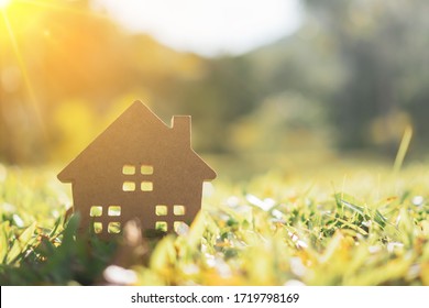 Closed Up Tiny Home Model On Green Grass With Sunlight Background.