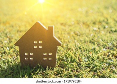 Closed Up Tiny Home Model On Green Grass With Sunlight Background.