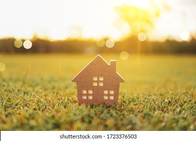 Closed Up Tiny Home Model On Green Grass With Sunlight Background.