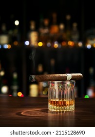 Closed up view of glass of whiskey with cigar on color  back