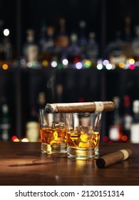 Closed up view of glass of whiskey with cigar on top on color back