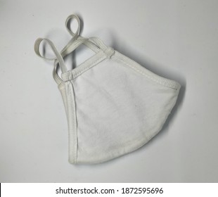 A Closed White Cloth Mask On A White Studio Background 