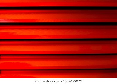 Closed window blind or shutter. Modern painted metal shutters. red background or surface. building exterior facade. Textural backdrop of wooden slats. Paint surface in light red. sstkbackgrounds - Powered by Shutterstock