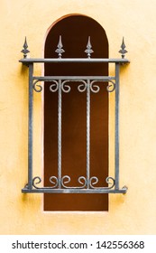 Closed windows covered with wrought iron of old building