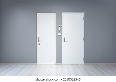 Closed Wooden Door Inside Empty Room At Front View. Entrance Of Room Inside House Building. Include Wooden Floor Or Laminate, Gray Wall. New Clean Surface Of Wooden Texture Look Modern At Night.