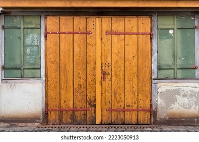 Closed, wooden double door or hinged door in an old, dilapidated building
