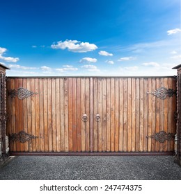 Closed wooden gates over sky background