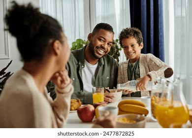 Close-knit African American family sharing food and conversation at the table. - Powered by Shutterstock