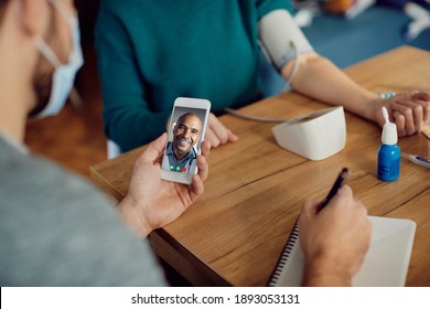 Close-p Of Happy Black Doctor Having Video Call With A Couple While They Are Measuring Blood Pressure At Home. 