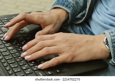Close-uA woman in a denim jacket is typing text on a laptop. Female fingers on the keyboard. Training, remote work.p of typing female hands on keyboard - Shutterstock ID 2214702275